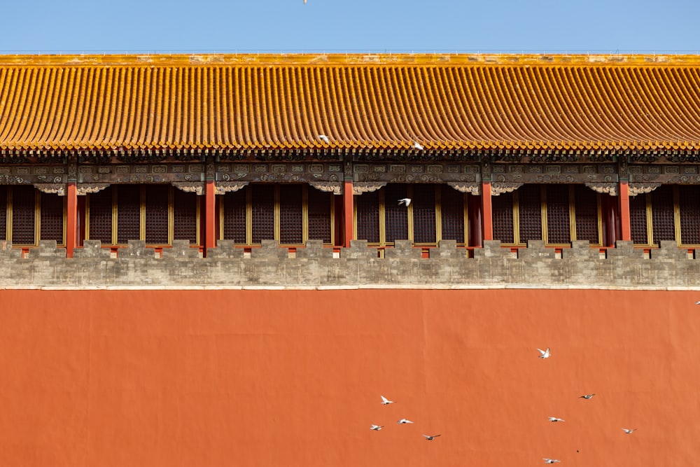 a building with a yellow roof and a red wall