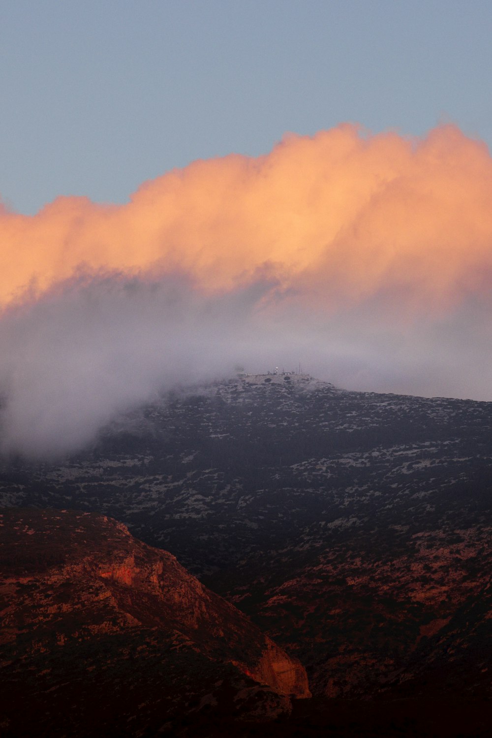 a mountain covered in a cloud covered sky