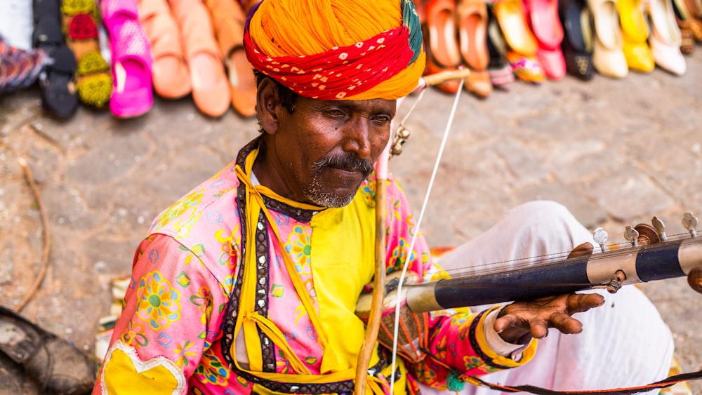 a man in a turban is holding a pipe