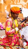 a man sitting on the ground playing a musical instrument