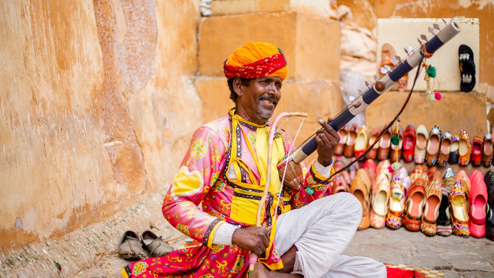 a man sitting on the ground with a sword in his hand