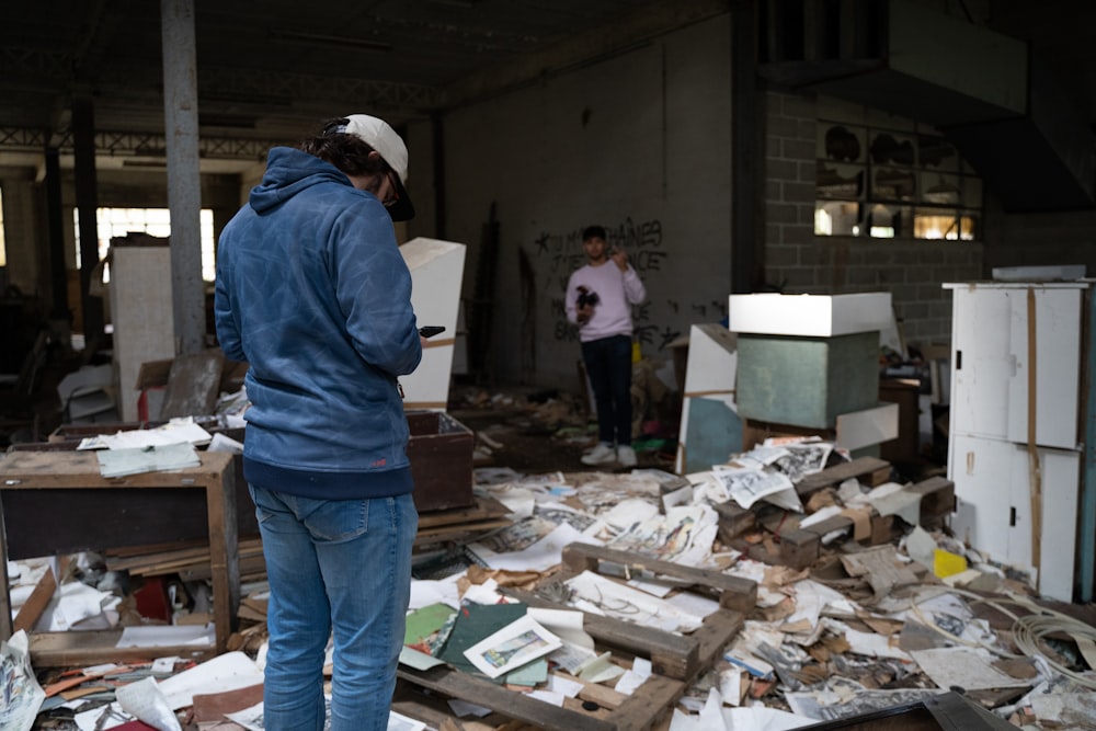 a man standing in a room full of junk