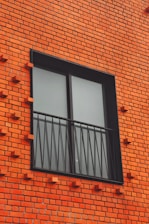 a red brick building with two windows and bars