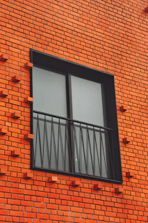 a red brick building with two windows and bars