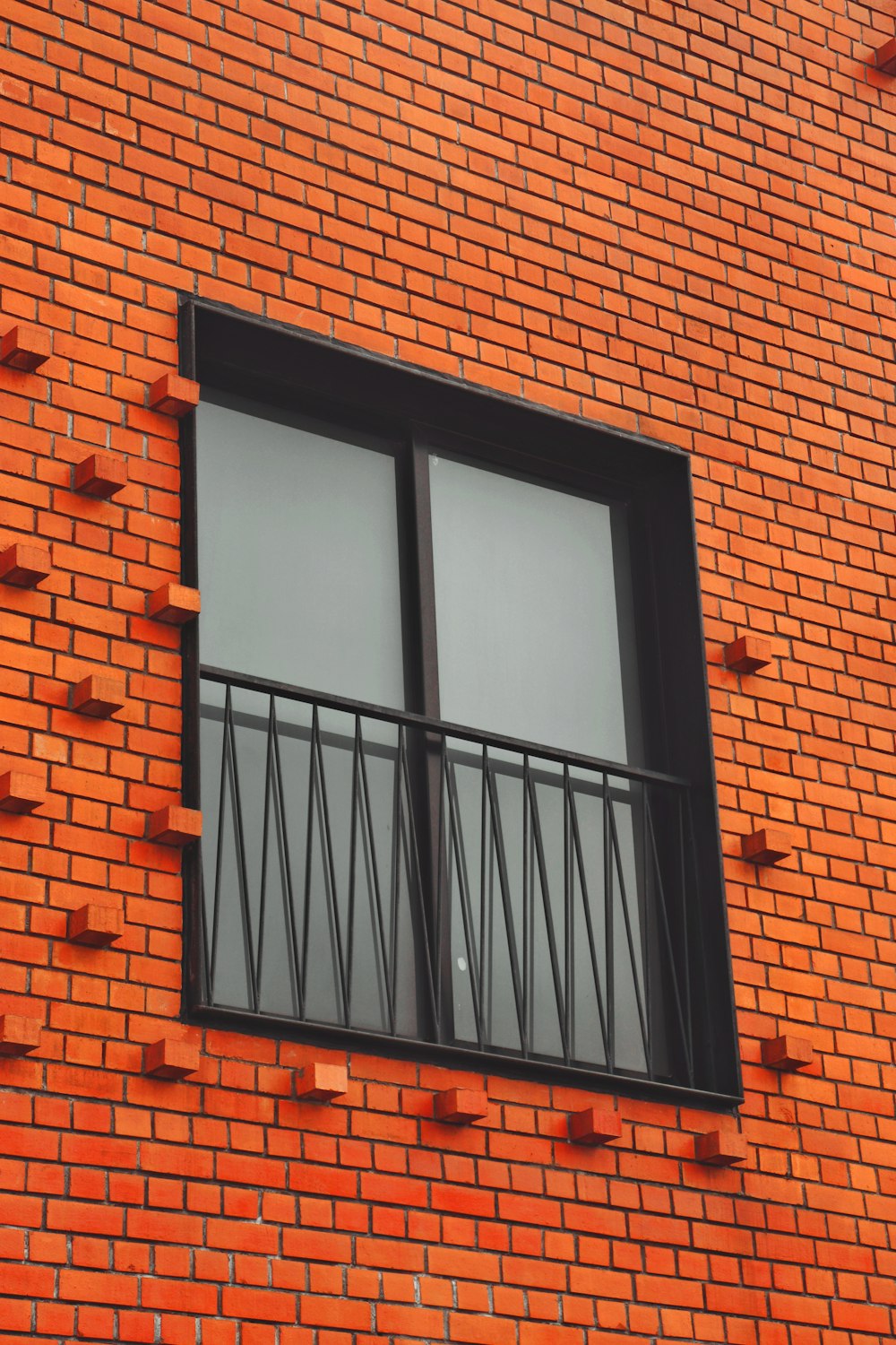 a red brick building with two windows and bars