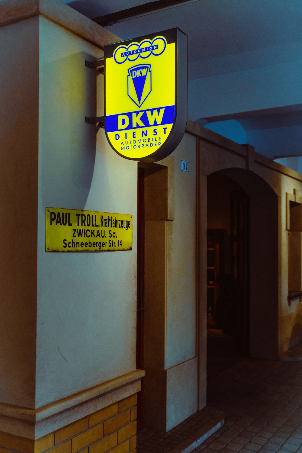 a yellow and blue sign hanging from the side of a building