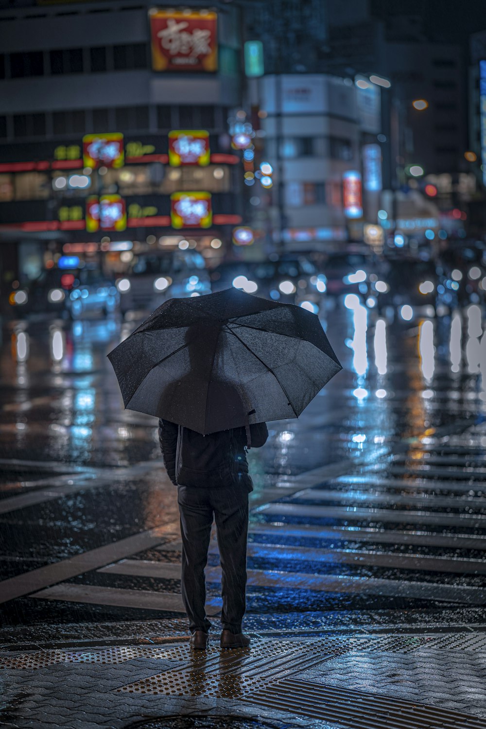 a man standing on a street holding an umbrella