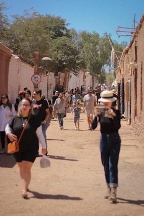A vibrant street scene in Vera, Santa Fe, showing local people and shops on a sunny day.