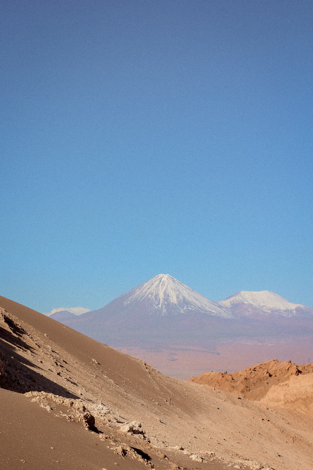 a man riding a horse on top of a sandy hill