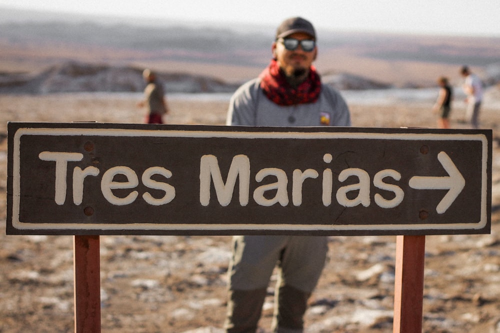 a man standing in front of a sign that says tres marjas