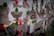 A collection of black and white tattoo designs on paper are pinned with bright pink and green circles on what seems to be a transparent or reflective surface. The designs include images of a moth, dice, a tiger, and a stylized key among others.