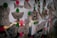 A collection of black and white tattoo designs on paper are pinned with bright pink and green circles on what seems to be a transparent or reflective surface. The designs include images of a moth, dice, a tiger, and a stylized key among others.