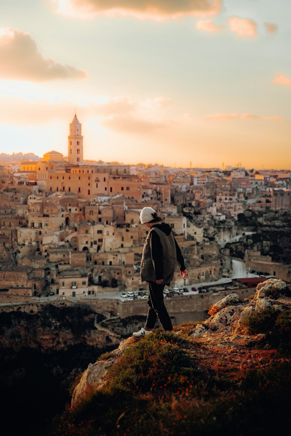 a man standing on top of a hill overlooking a city