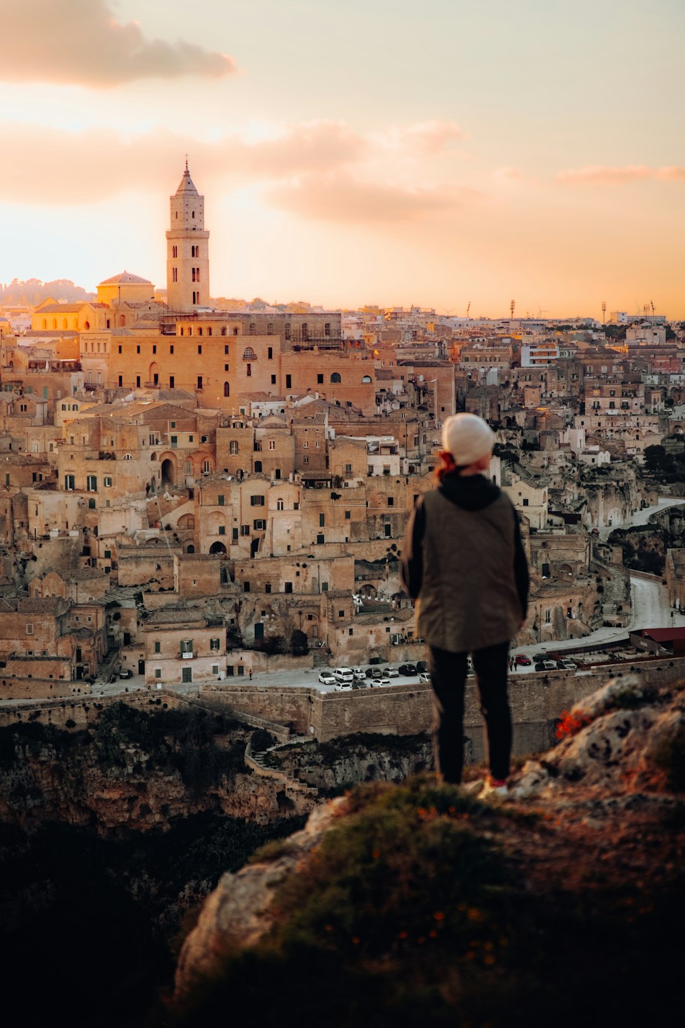 a person standing on a hill overlooking a city