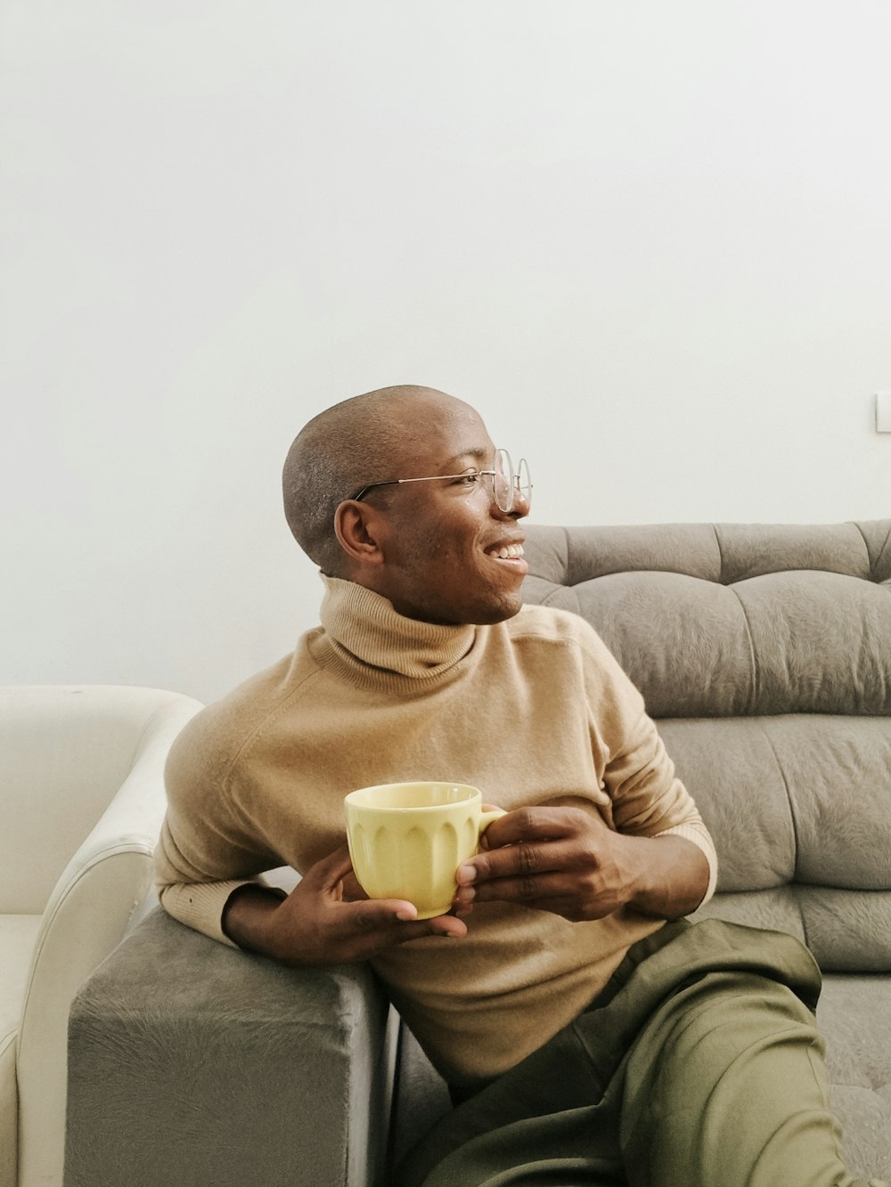 a man sitting on a couch holding a cup