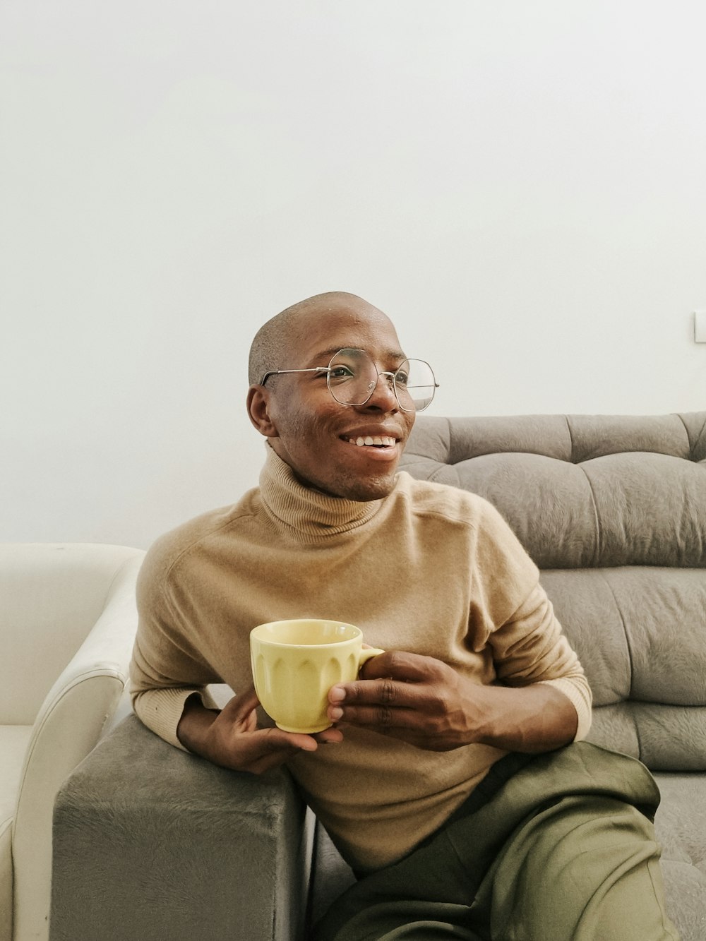 a man sitting on a couch holding a cup