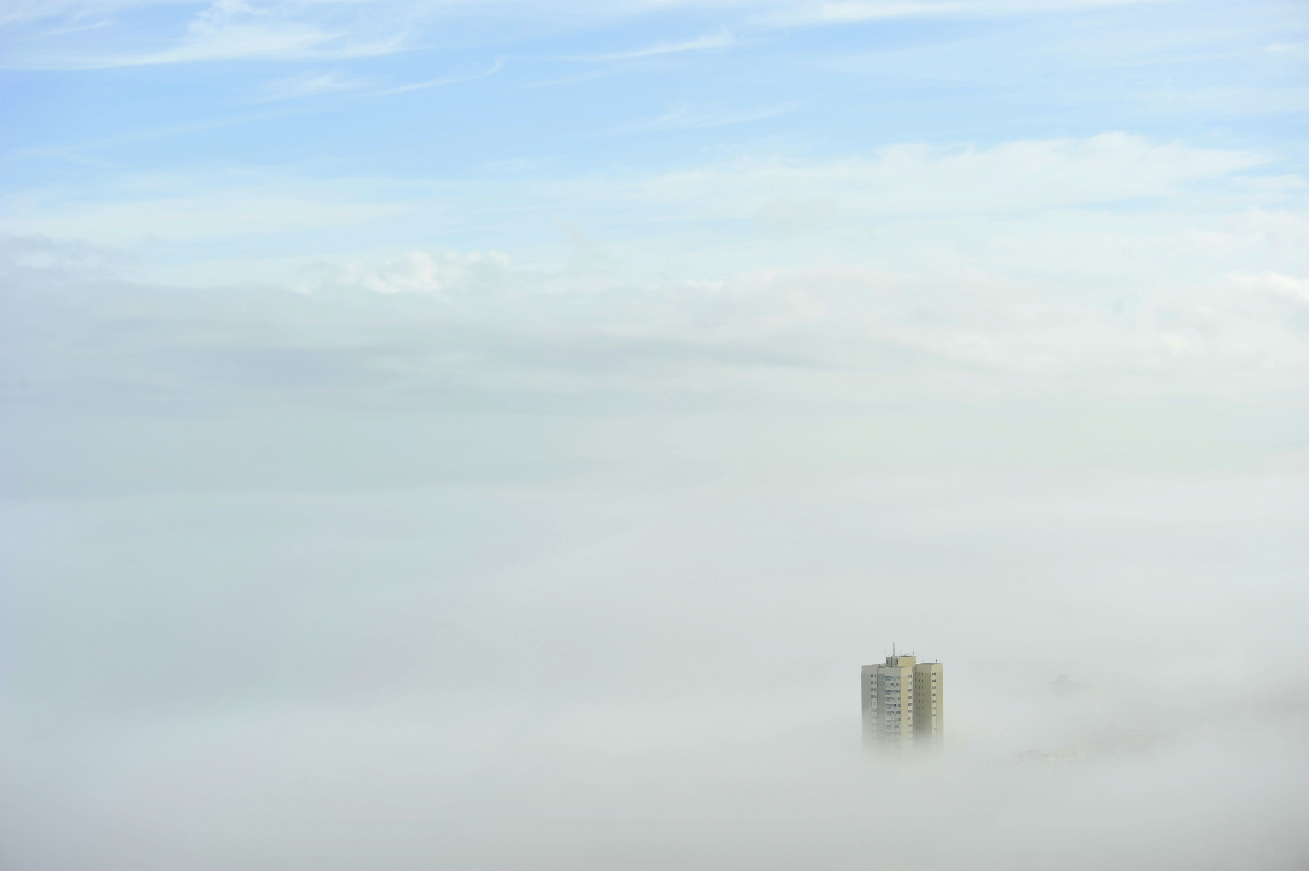 a tall building in the middle of a foggy city