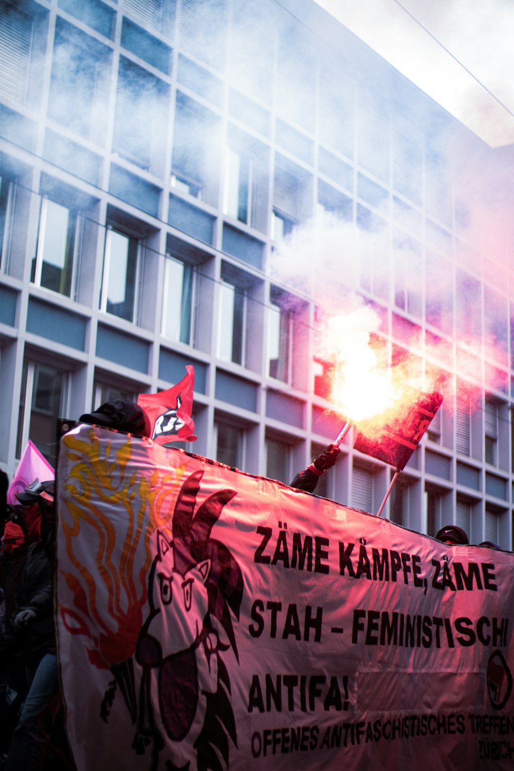 a group of people holding a large red banner