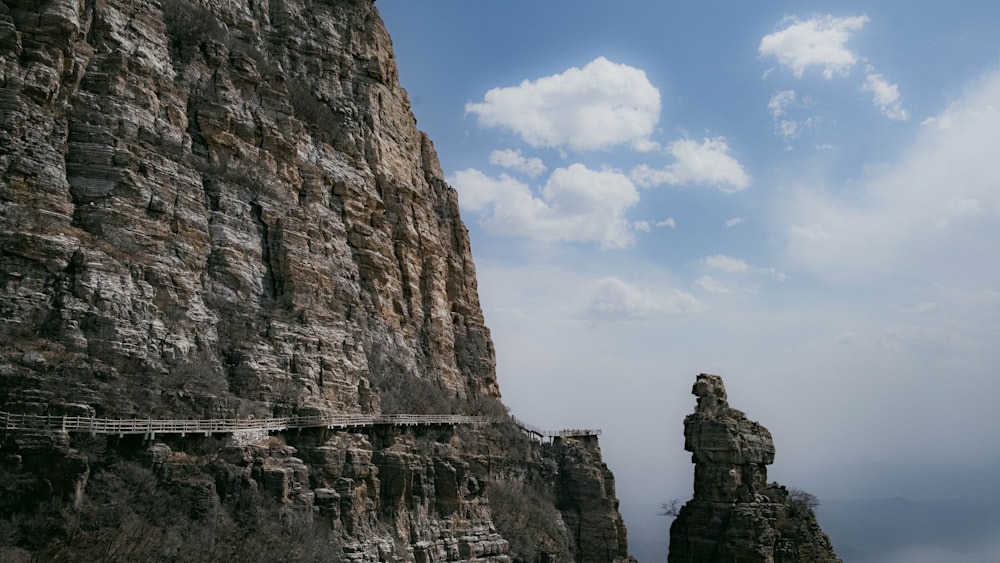 a very tall cliff with a bridge going over it