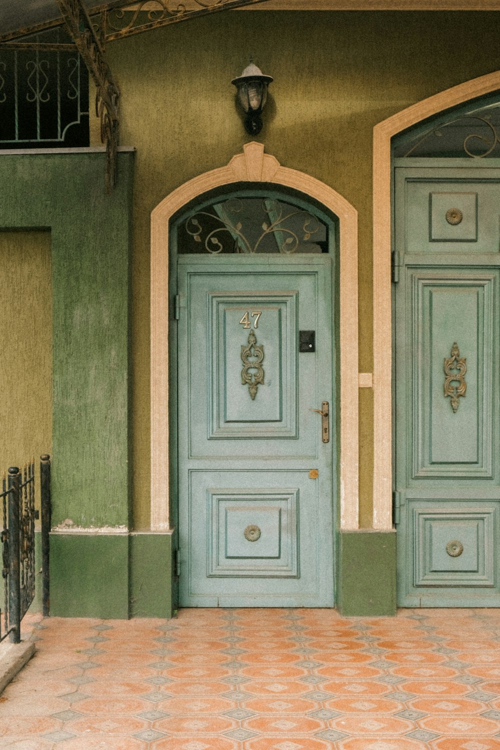 a couple of blue doors in front of a green building