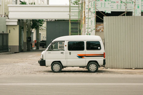A mobile welding van parked at a construction site with tools and equipment visible inside.