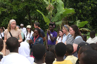 A team discussing environmental plans outdoors with greenery around.