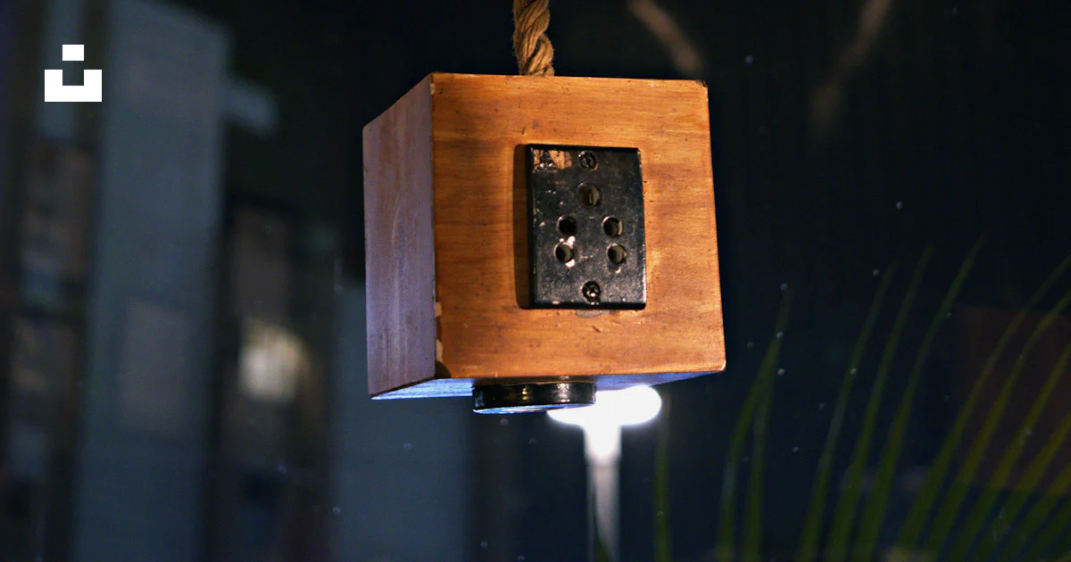 A wooden object hanging from a rope in a room photo – Free Wood Image ...