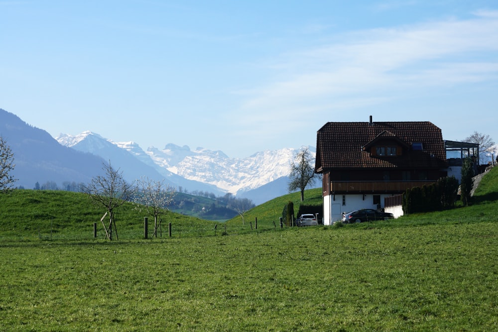 a house in a field with mountains in the background
