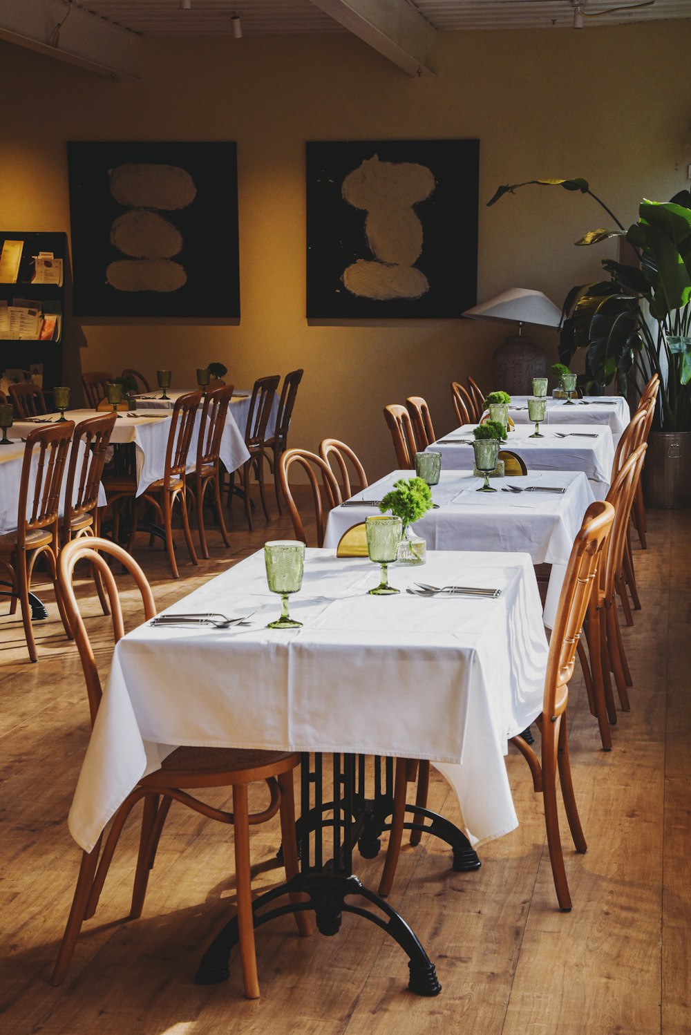 a dining room with tables and chairs with white tablecloths