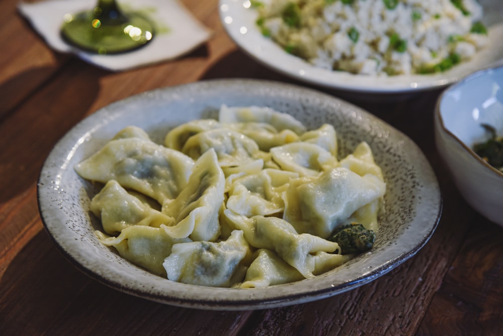 a bowl of dumplings and a bowl of rice on a table