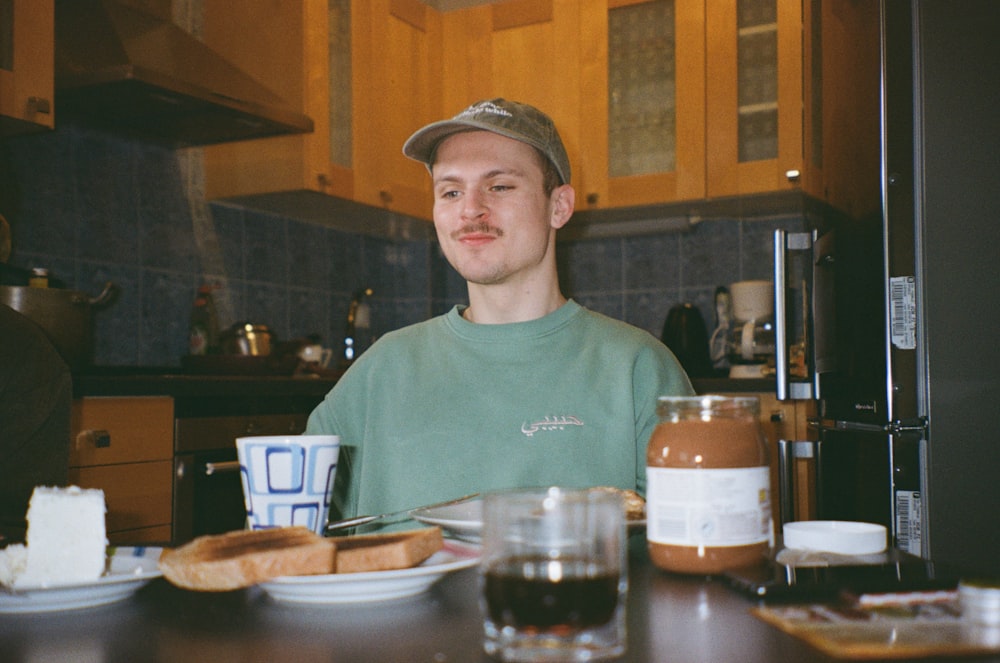 a man sitting at a table with a plate of food