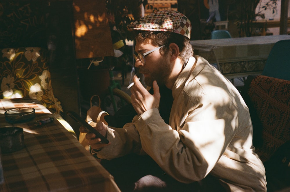 a man sitting at a table using a cell phone