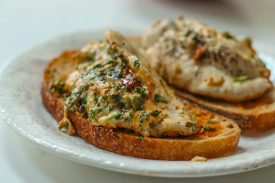 Fresh white chicken breasts arranged neatly with herbs and lemon slices