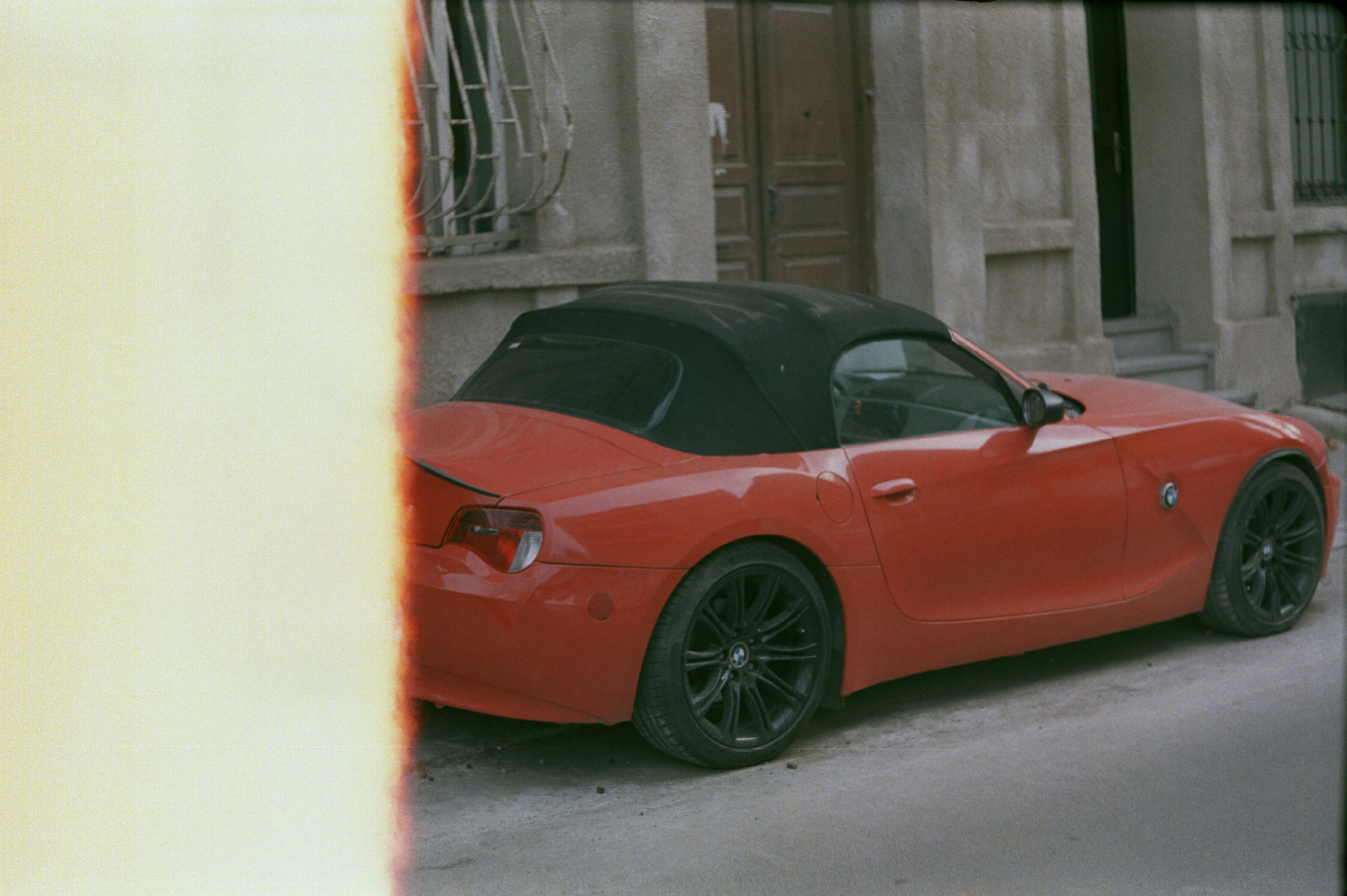 A red sports car parked in front of a building photo – Free Bmw Image ...