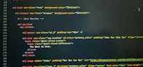 A computer screen displaying code with HTML-like tags and inline CSS styles. The code featured includes elements such as mj-body, mj-wrapper, and mj-text with specific styling for background colors, padding, alignment, and text content. Notable text within the code includes 'The Wait Is Over.'