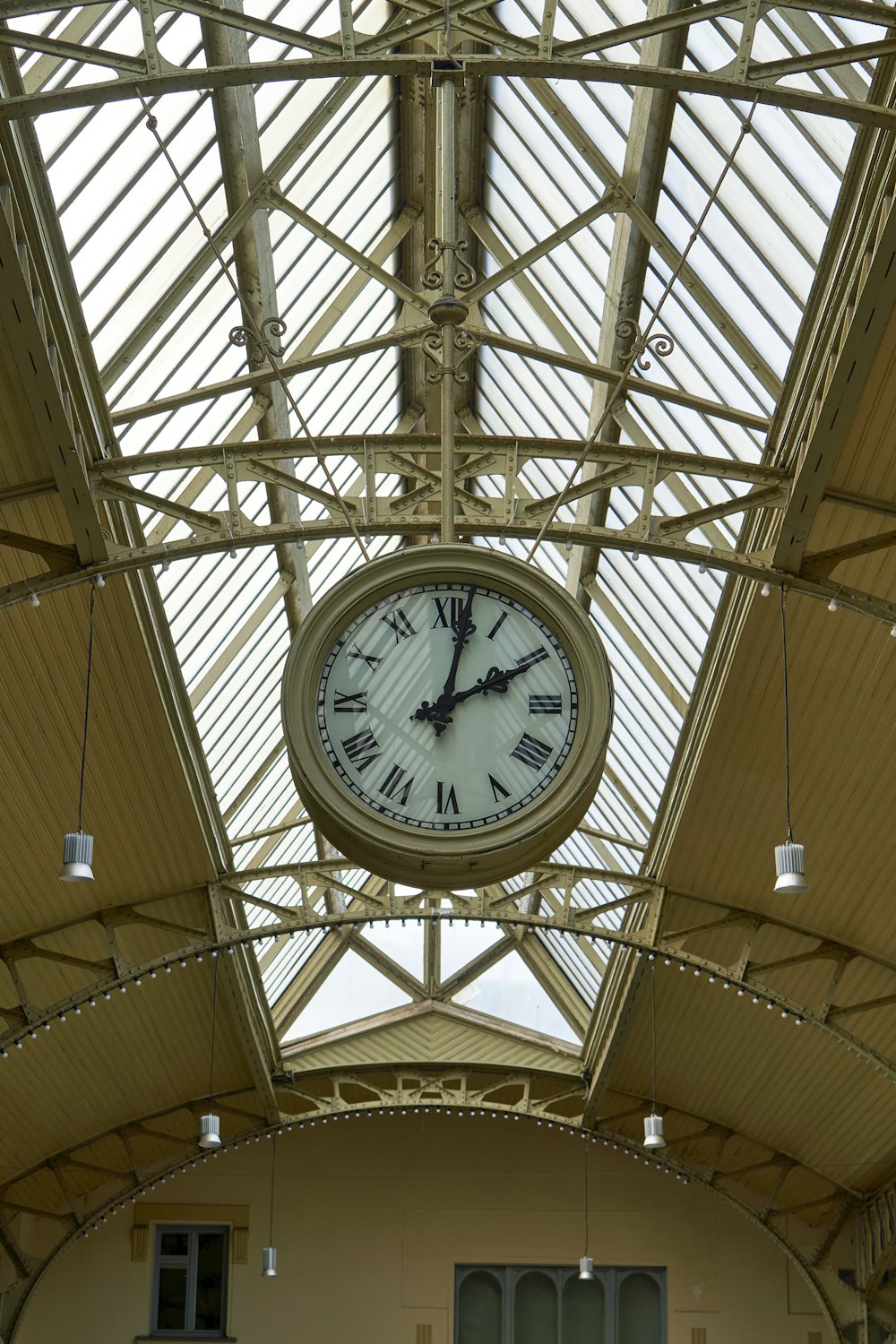 a clock hanging from the ceiling of a building