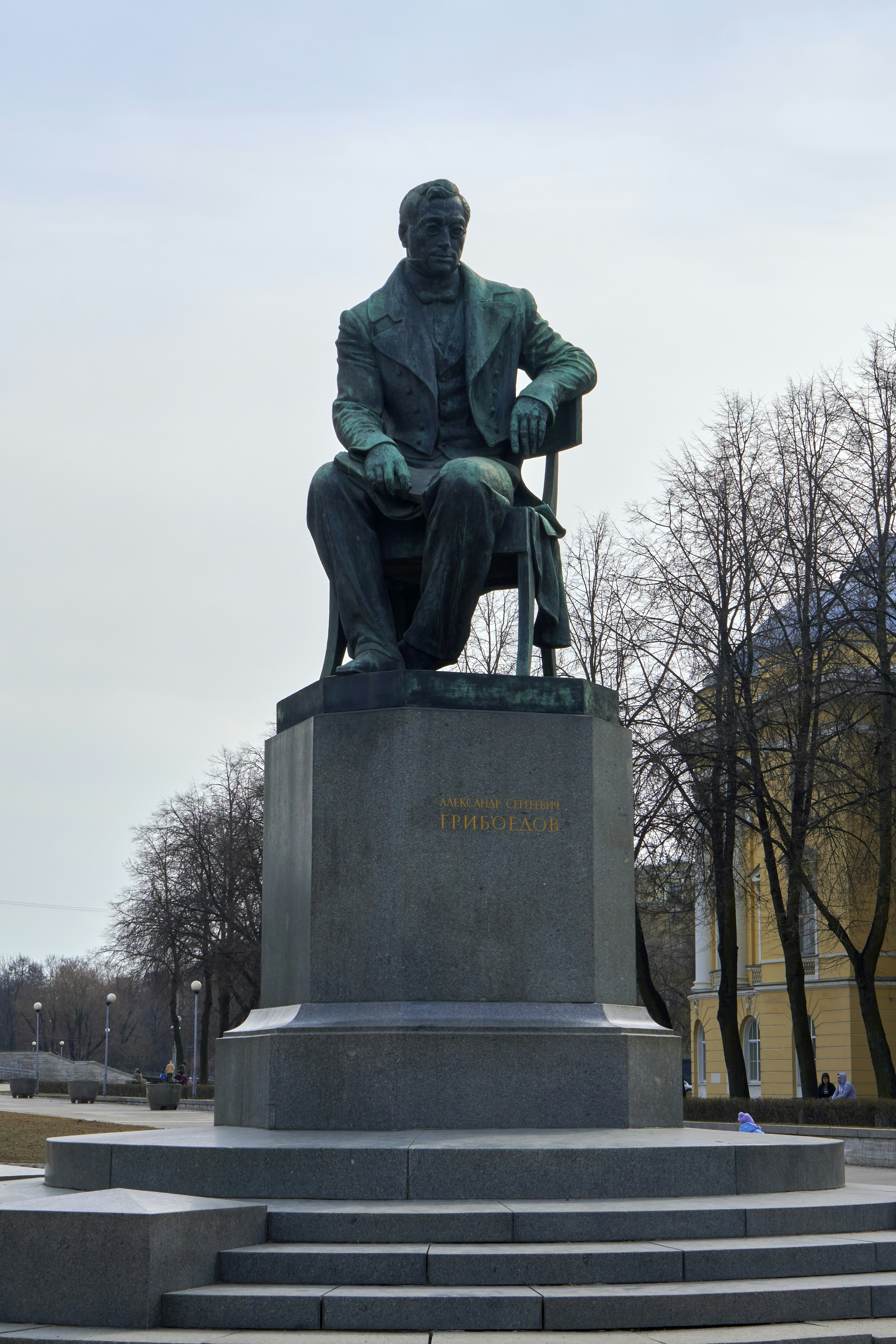 a statue of a man sitting on a bench