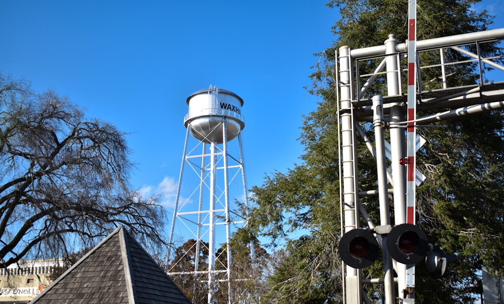 a tall white water tower next to a traffic light