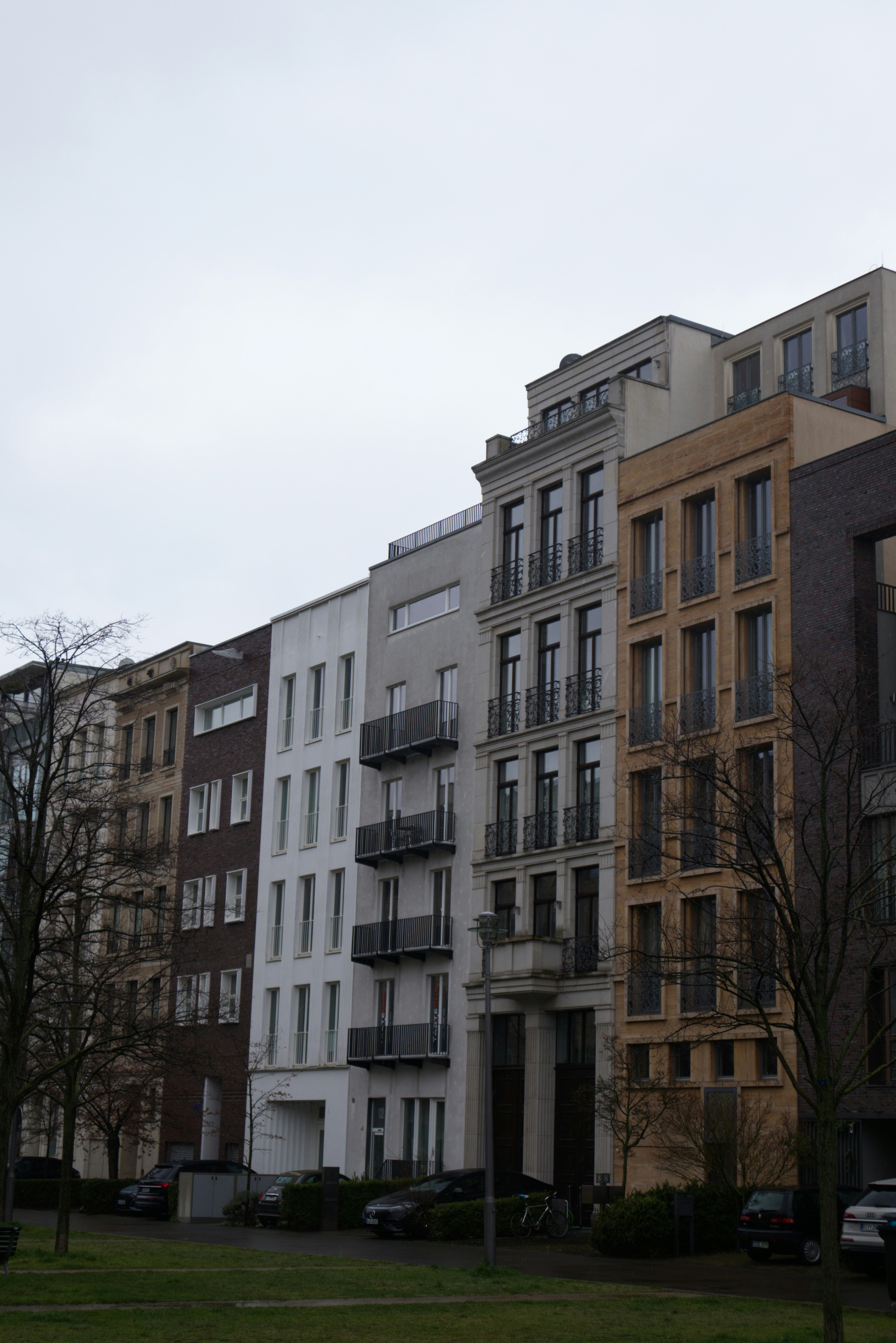 a row of multi - story apartment buildings on a cloudy day