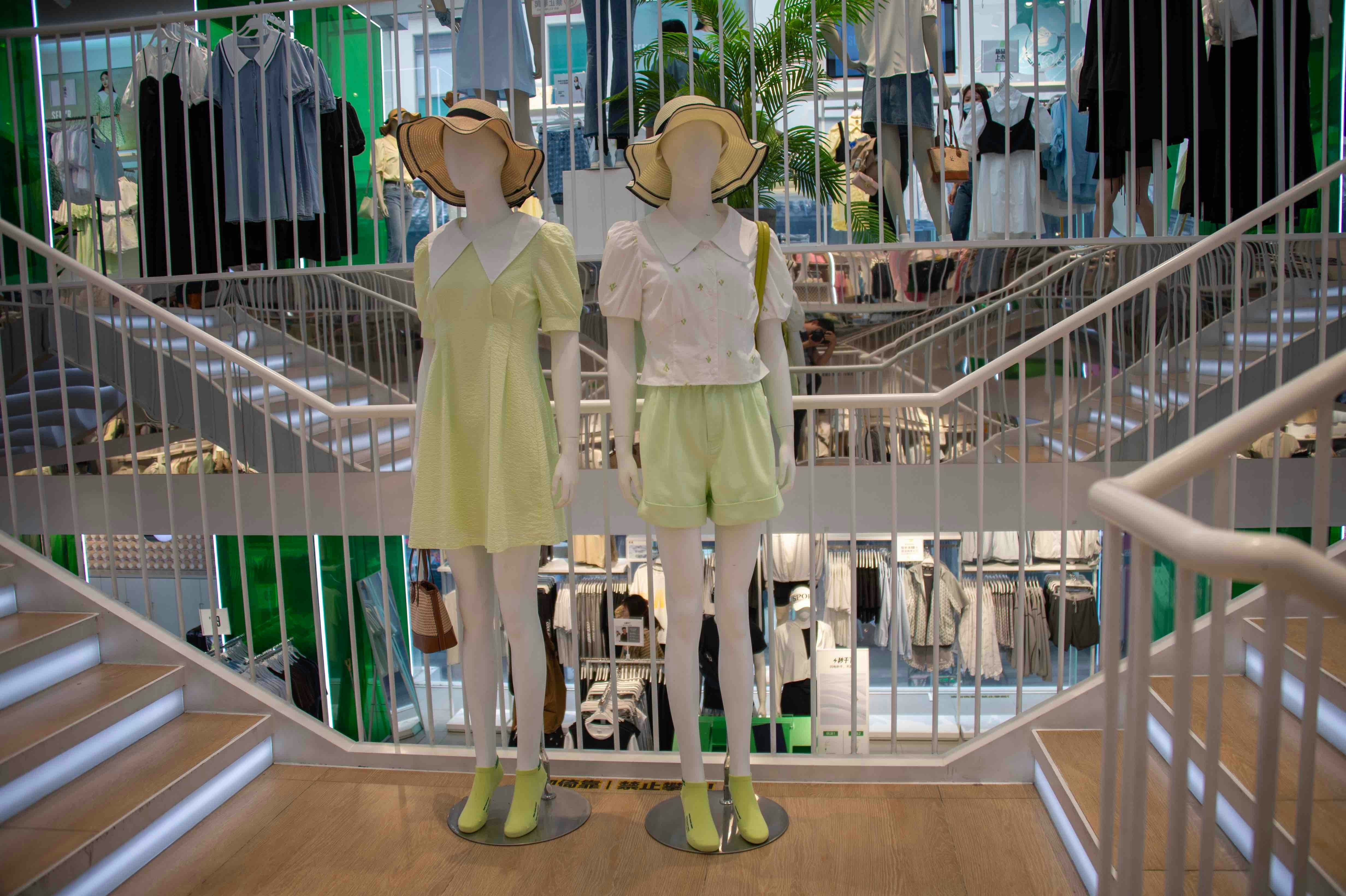 two mannequins dressed in yellow and green in a clothing store