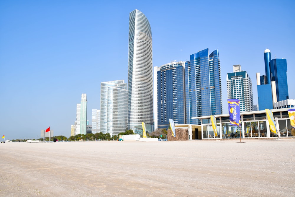 a sandy beach with tall buildings in the background