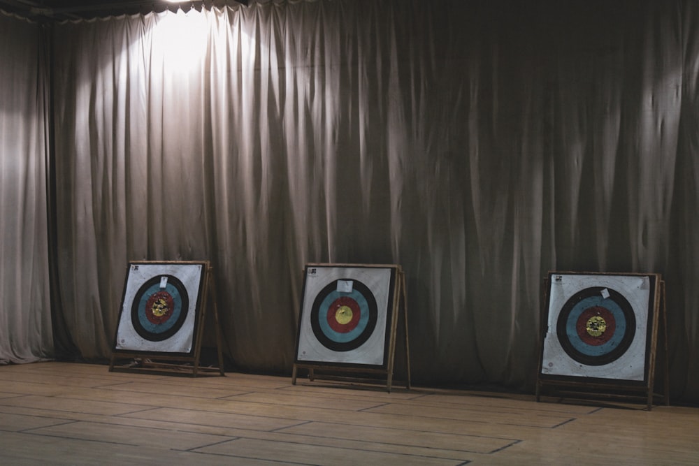 three archery target in front of a curtain