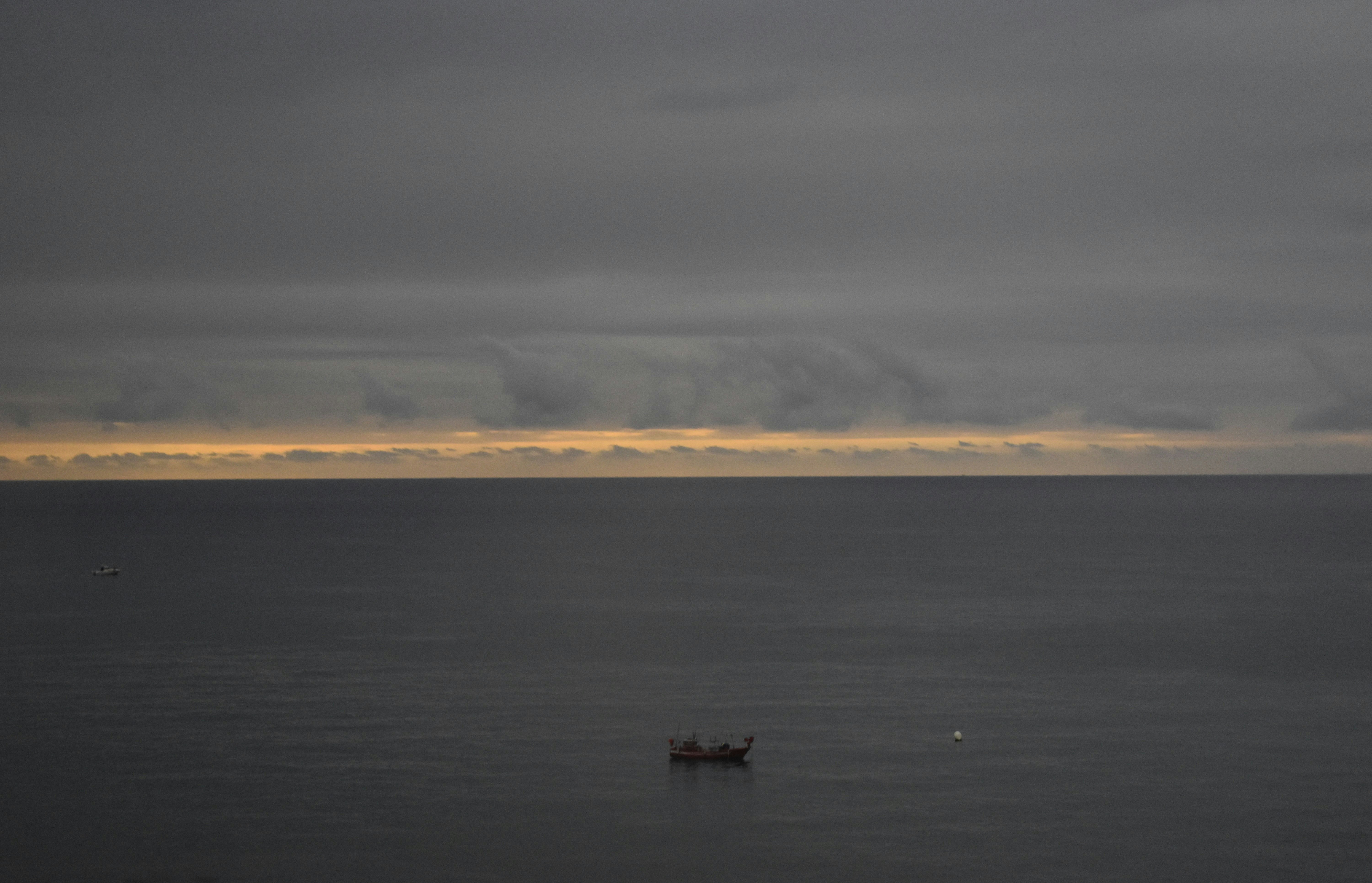 a small boat floating on top of a large body of water
