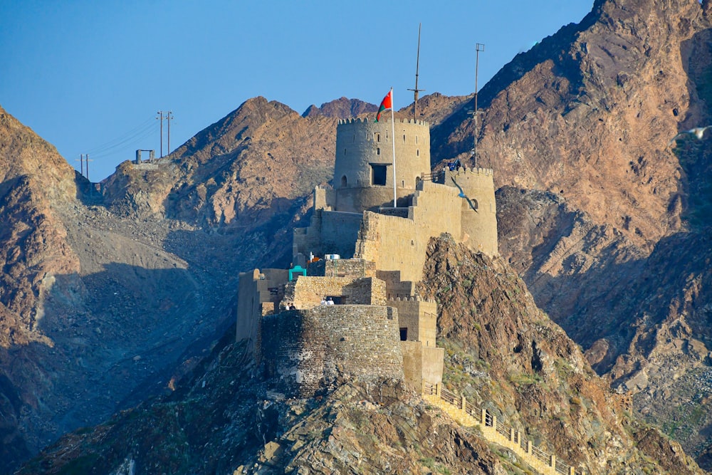 a castle on top of a mountain with mountains in the background