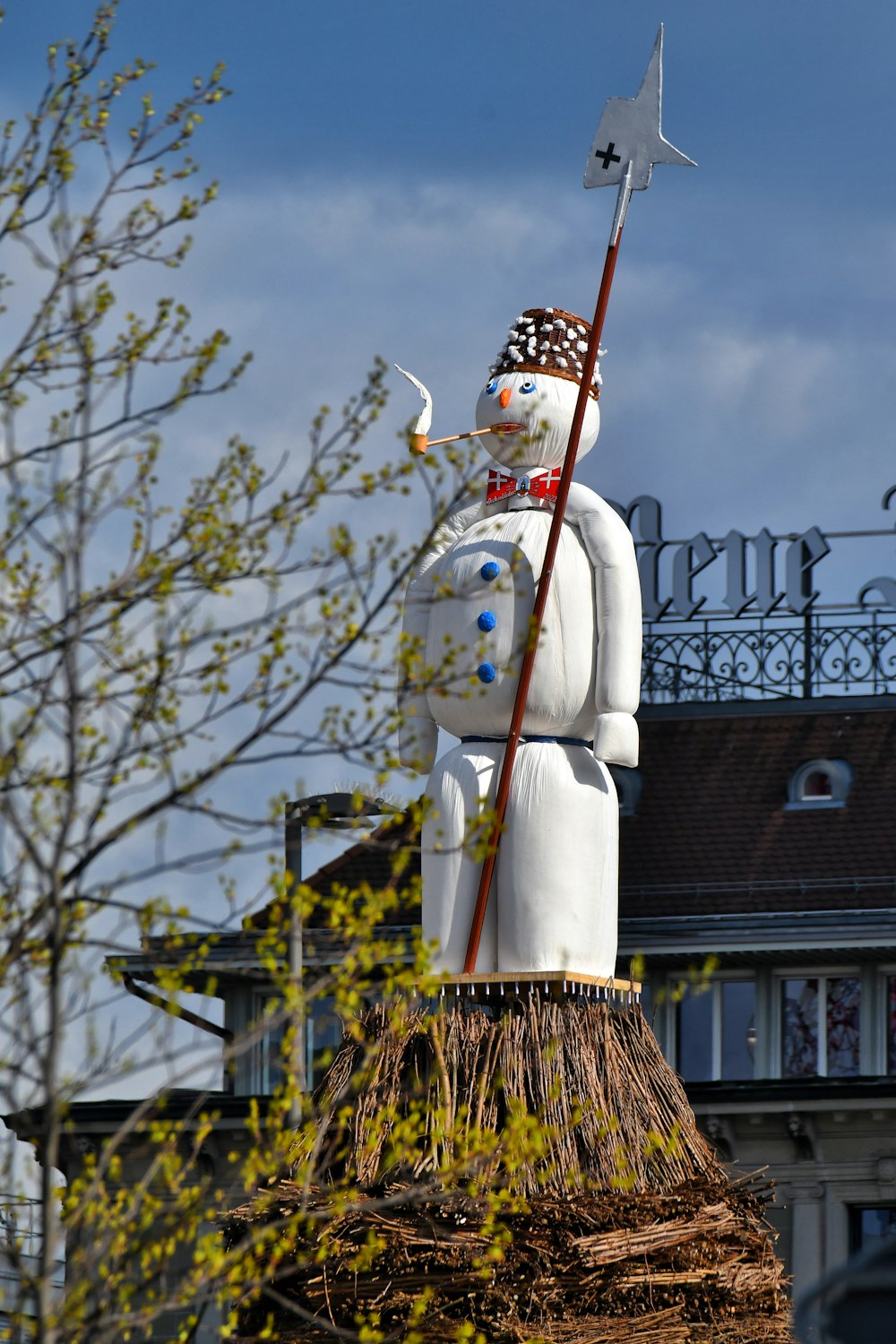 a statue of a snowman holding a flag on top of a roof