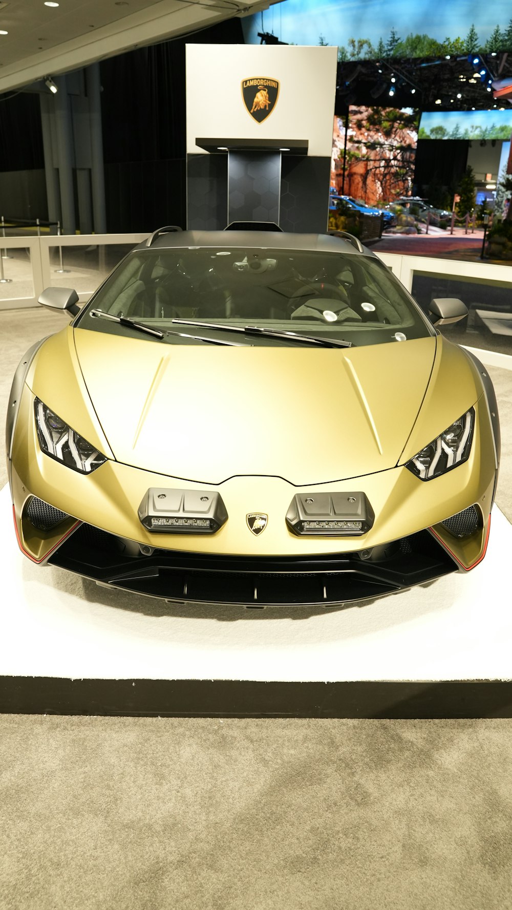 a gold colored sports car on display at a car show
