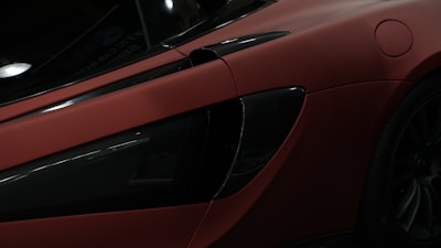 Close-up of a sleek car being wrapped with a vibrant matte film in a modern workshop.