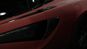 Side view of a sleek black sports car with a flawless ceramic coating under soft lighting.