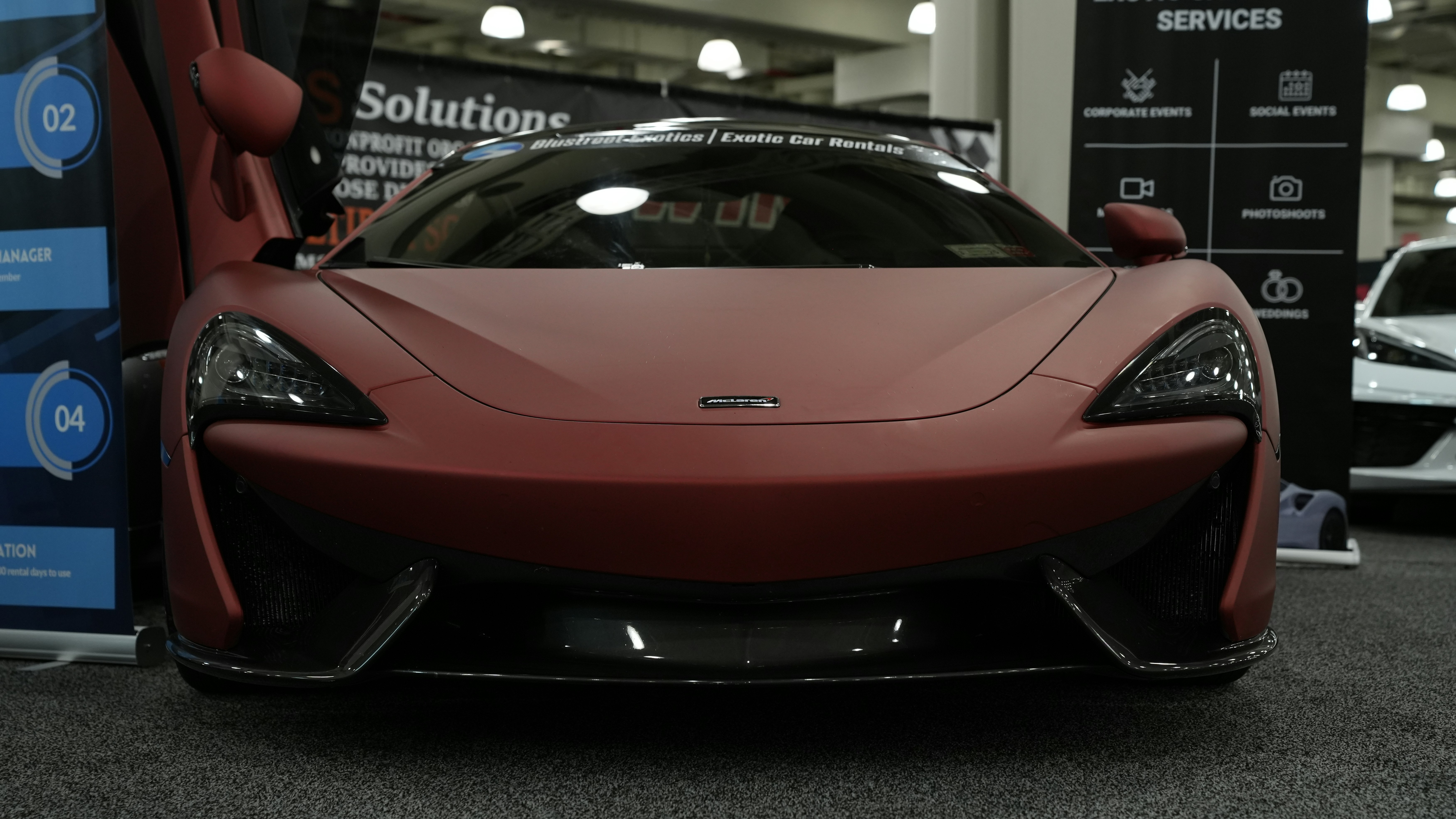 Ein roter Sportwagen, der in einem Ausstellungsraum geparkt ist