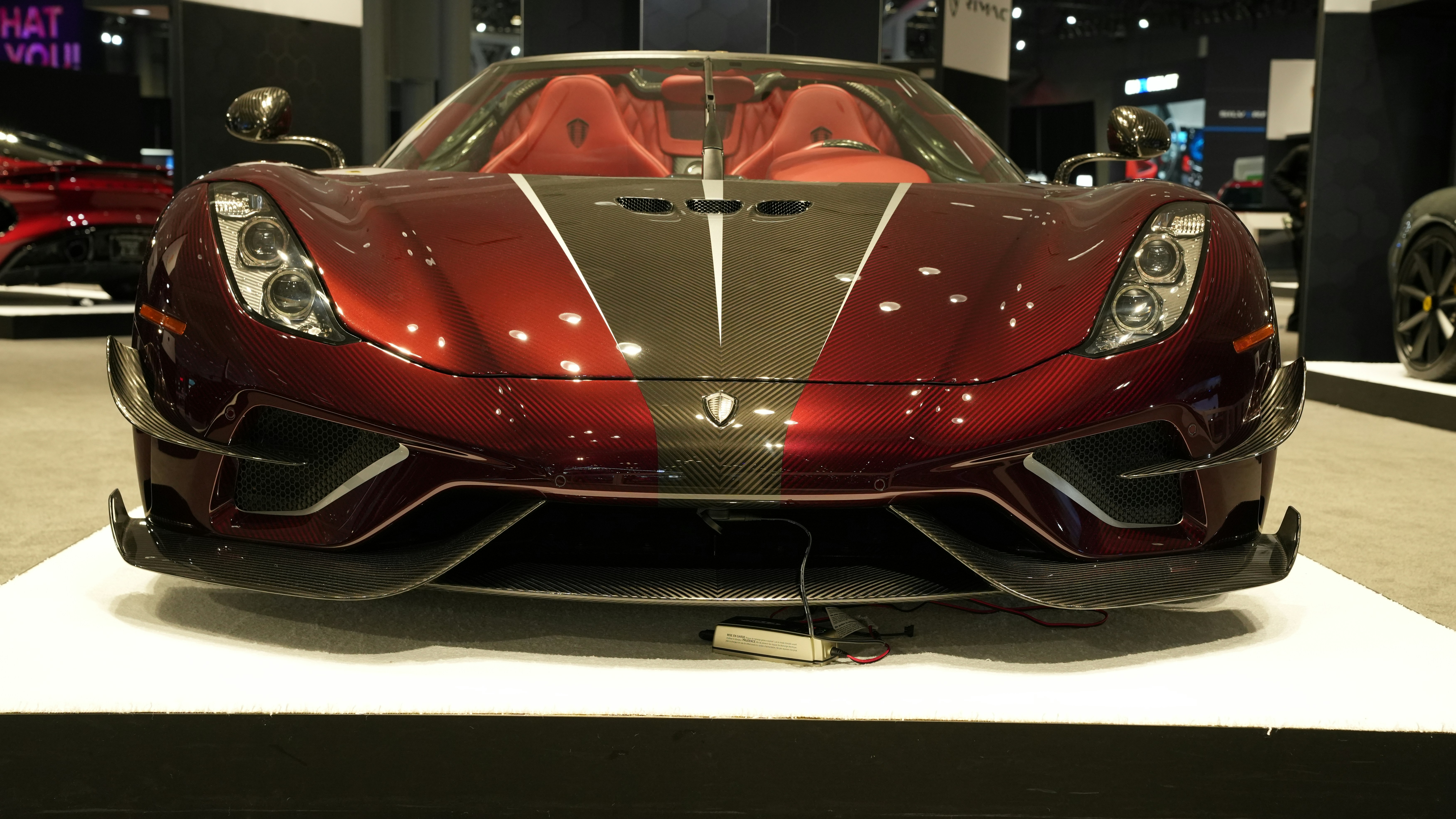 a red sports car on display at a car show, 